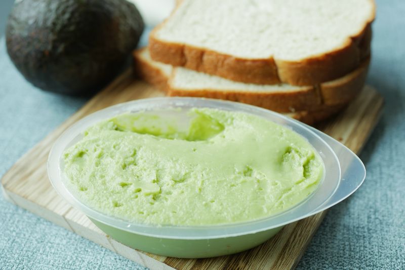 Smashed avocado sandwich on artisan bread with microgreens